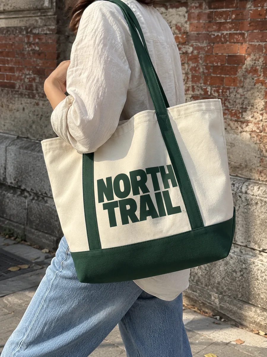 "NORTH TRAIL" print, forest-green bottom and handles, on the shoulder