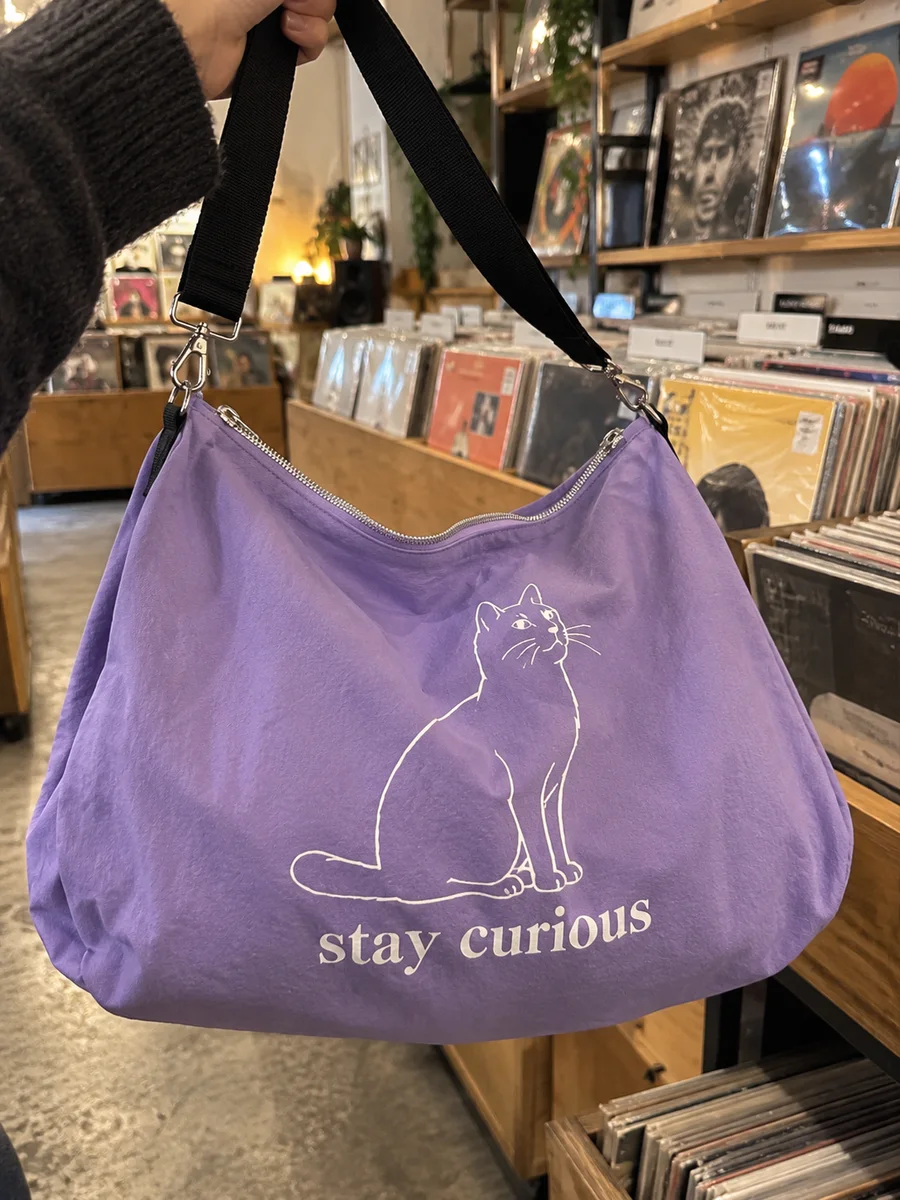Lilac bag, white "stay curious" line-art print, close-up