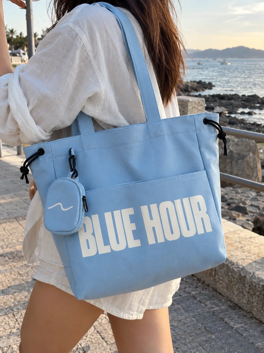 Light-blue bag, white "BLUE HOUR" print, on the shoulder