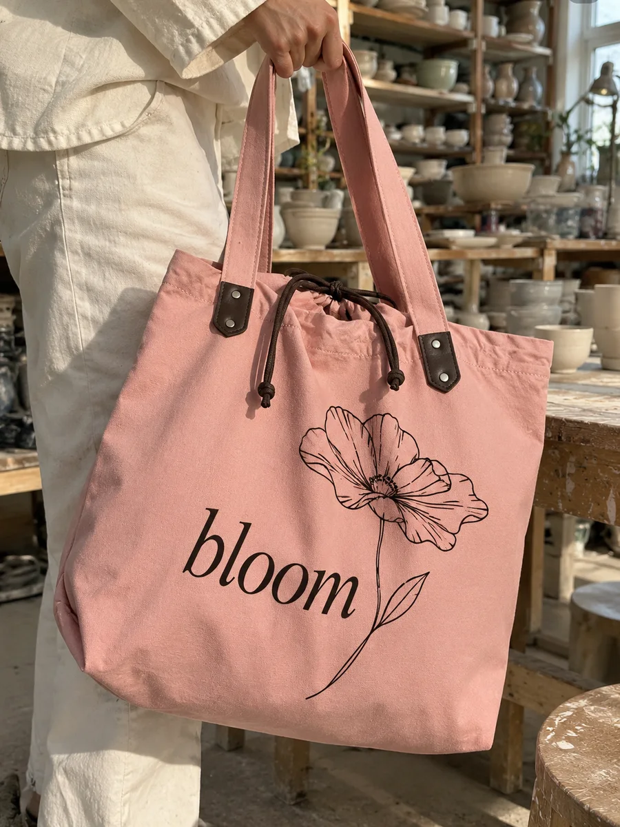Dusty-pink bag, black "bloom" line-art print, close-up